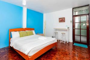 una camera con un grande letto con una parete blu di Krabi town Guesthouse a Krabi town