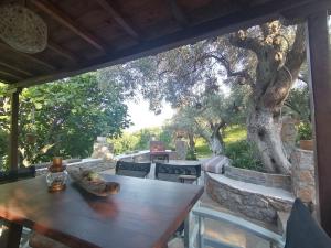 a table and chairs on a patio with a tree at Vasilis' kalivi in Skiathos