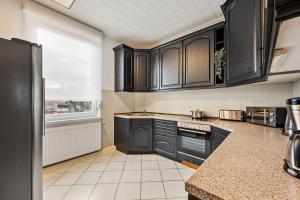 eine Küche mit schwarzen Schränken und einer Arbeitsplatte in der Unterkunft Sali Homes - Heilbronn Süd in Heilbronn