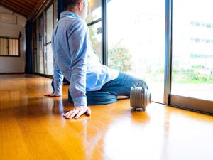 un homme assis à même le sol avec une valise dans l'établissement WE HOME STAY Kawagoe Matoba - Vacation STAY 14666v, à Kawagoe