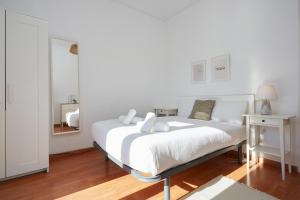a white bedroom with a large bed and a mirror at 53PAR389 - Magnifico piso en el centro de Poble Sec in Barcelona