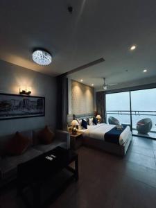een grote slaapkamer met een bed en een bank bij Luxuria Studio Apartment in New Delhi