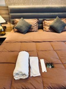 een bed met twee handdoeken en twee slippers erop bij Luxuria Studio Apartment in New Delhi