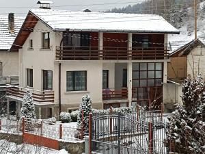 una casa con una valla en la nieve en Самостоятелна къща за гости Рилски кът Маджаре, en Madzhare