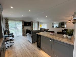 a kitchen and living room with a couch and a table at The Luxurious Langdale 6 Lodge at Park Dean White Cross Bay, Lake Windermere in Windermere