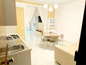 a kitchen and dining room with a table and chairs at Antica Dimora-luxury historic apartment in Vibo Valentia