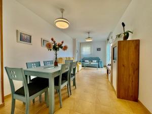 a dining room and living room with a table and chairs at Apartamento con vistas al mar en urbanización de lujo Almerimar in Almerimar