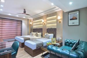 a hotel room with two beds and a couch at Hotel Oak Plaza, New Delhi in New Delhi