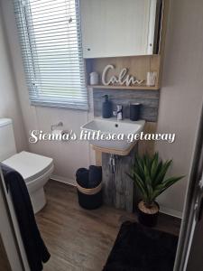 a bathroom with a white toilet and a sink at Sienna's littlesea getaway in Wyke Regis