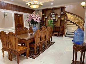 uma sala de jantar com uma mesa e cadeiras e uma escadaria em Villa Hotel Thao Nguyen em Da Lat
