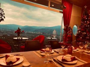 a dining room with a christmas tree and a table with wine glasses at Nacasoo hill in Tiên Hai