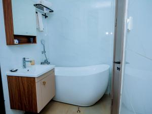 y baño con bañera blanca y lavamanos. en 5 Elizabeth Golf Apartment, en Kigali