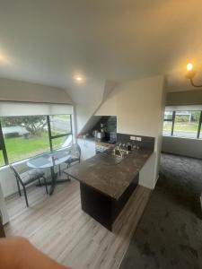 a kitchen with a sink and a table in a room at Ohope Dreamer 1 in Ohope Beach