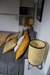 Cette chambre comprend un lit avec des oreillers jaunes et une chaise. dans l'établissement Dolce Vita Millau, à Millau