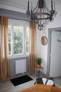 a living room with a window and a chandelier at Dolce Vita Millau in Millau