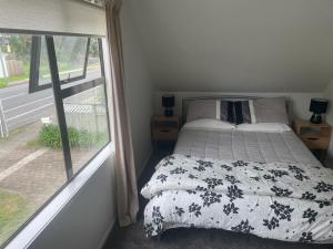 a bedroom with a bed and a large window at Ohope Dreamer 1 in Ohope Beach