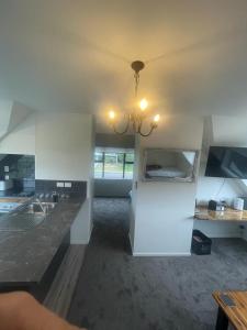 a room with a kitchen with a sink and a chandelier at Ohope Dreamer 1 in Ohope Beach