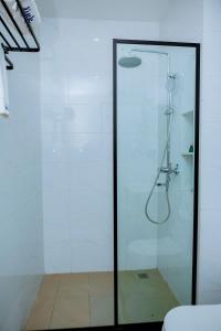 y baño con ducha y puerta de cristal. en 5 Elizabeth Golf Apartment, en Kigali