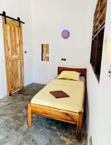 um quarto com uma cama em um quarto com uma porta em Amistad em Ouidah