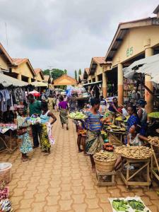 Un groupe de personnes se promenant à travers un marché en plein air dans l'établissement Amistad, à Ouidah