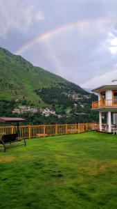 a rainbow in the sky over a house with a yard at The Swat House in Swat