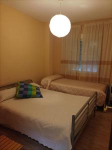 1 dormitorio con 2 camas y lámpara de araña en Casa Rural San Gines, en Sabiote