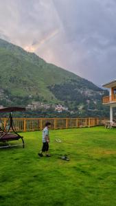 a boy is playing with a frisbee in a field at The Swat House in Swat