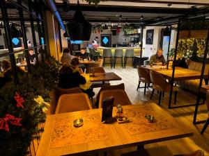 a group of people sitting at tables in a restaurant at Grand Apartman Kopaonik in Kopaonik