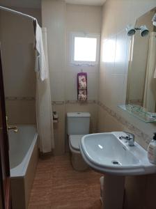 ein Badezimmer mit einem Waschbecken, einem WC und einer Badewanne in der Unterkunft Casa Rural San Gines in Sabiote