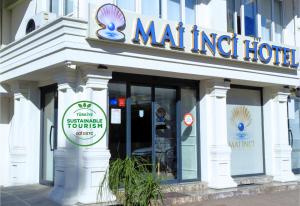a restaurant with a sign on the front of a building at Mai İnci Otel in Antalya