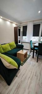 a living room with a green couch and a table at Apartament 43 in Płock