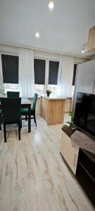 a living room with a television and a table and chairs at Apartament 43 in Płock