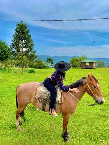 聖若澤－杜斯奧森蒂斯的住宿－POUSADA FAZENDA PAIM，田野里骑马的女人
