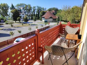 a balcony with chairs and a table and a view of a street at Apartmán Jezerska in Subotica