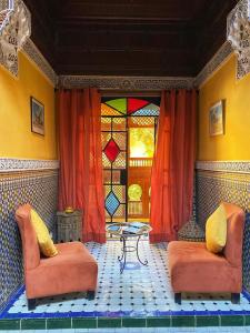 een kamer met 2 stoelen, een tafel en een glas-in-loodraam bij Ryad El Borj in Marrakesh