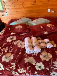 Una cama con almohadas y un edredón. en POUSADA FAZENDA PAIM, en São José dos Ausentes