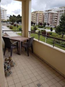 balcone con tavolo, sedie e vista sugli edifici di Appartamento residenziale con posto auto privato a Sassari