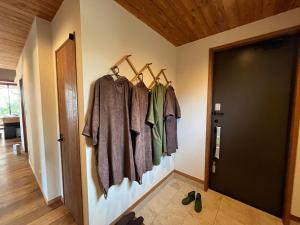 a hallway with clothes hanging on a wall at ガーデンヴィラ白浜　KOTI in Shimoda