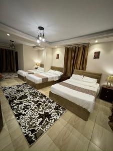 a bedroom with two beds and a rug at Hur magic inn in Cairo