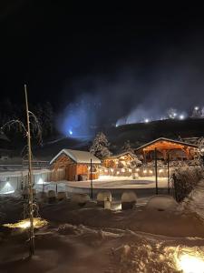 eine schneebedeckte Stadt in der Nacht mit Gebäuden in der Unterkunft Aparthotel Narciarska 2 in Korbielów