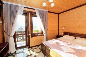 a bedroom with a bed and a large window at Бесаги in Yaremche