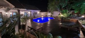 un patio trasero con piscina por la noche en Leopard Tree Lodge, en St Lucia