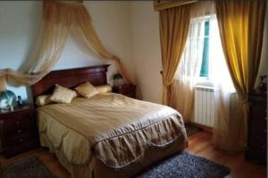 a bedroom with a bed and a window with curtains at Global Guest Rooms in Sintra