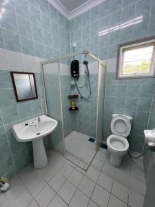 La salle de bains est pourvue d'une douche, de toilettes et d'un lavabo. dans l'établissement Sunny Lake House, à Behrang Hulu