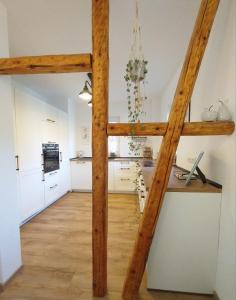 a large kitchen with white cabinets and wooden beams at Familien-Apartment SchmitTs Katz 