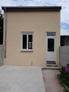 Casa amarilla con puerta blanca y ventanas en MAISON INDEPENDANTE, en Revin