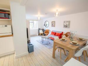 a living room with a table and a kitchen at Pass the Keys Stylish apartment in peaceful Oxfordshire suburb in Kidlington