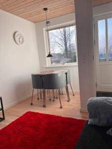 格斯廷的住宿－Hyggelig lejlighed i Rinkenæs，一间设有桌子和红色地毯的用餐室