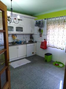 a kitchen with white cabinets and a green ceiling at Global Guest Rooms in Sintra