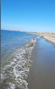a beach with water and footprints in the sand at Apartamento con vistas al mar en urbanización de lujo Almerimar in Almerimar